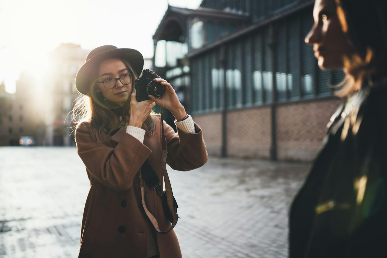 Kvinne fotograferer en annen kvinne i byen